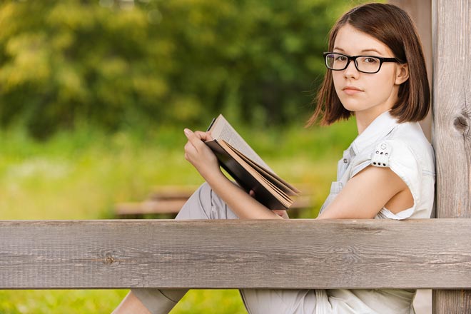 Κορίτσι διαβάζει βιβλίο σε εξωτερικό χώρο.